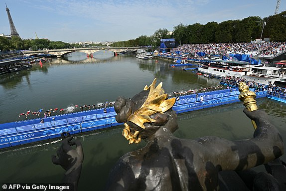 Competitors jump into the Seine river for the swimming phase of the triathlon.