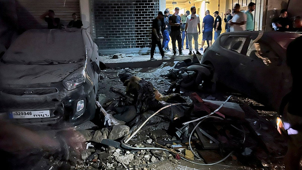 People examining damaged vehicles in the southern suburbs of Beirut following an Israeli airstrike targeting Hezbollah's stronghold on July 30, 2024.