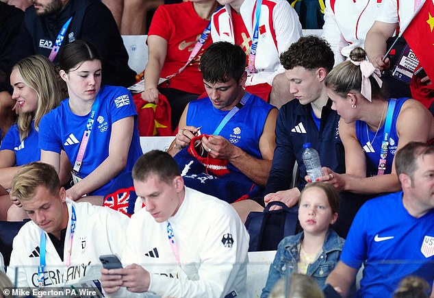 Tom Daley knits as he watches the women's synchronised 3m springboard final