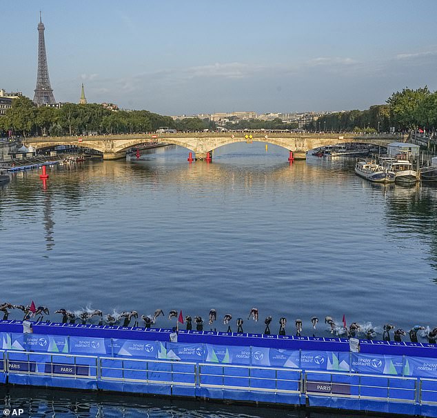 Athletes diving into the Seine River during a triathlon test event
