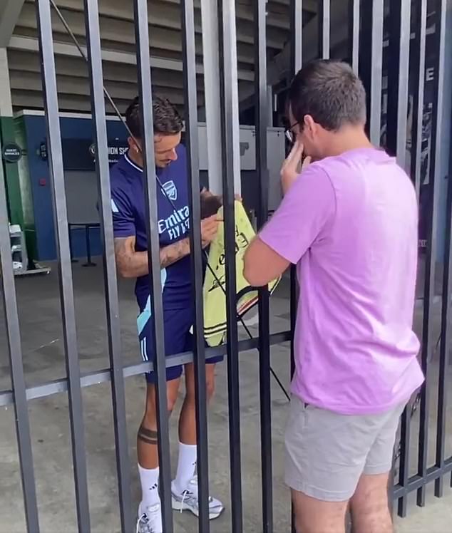 The fan tearfully watches as White signs his shirt