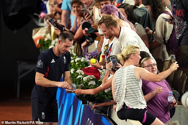 Murray signs autographs for fans after taking another dramatic victory in the men's doubles