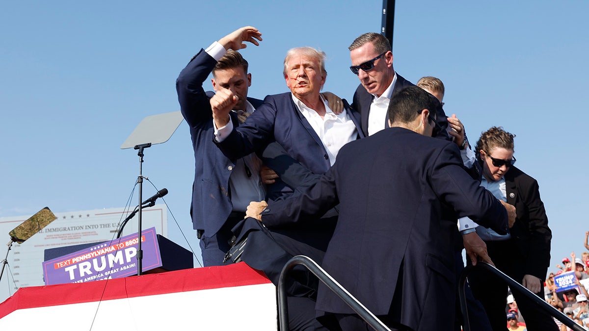 Former President Donald Trump is rushed offstage