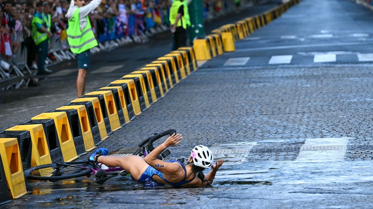 Guam's Manami Iijima crashes as she competes in the cycling race during the women's individual triathlon at the Paris 2024 Olympic Games in central Paris on July 31, 2024. (Photo by Ben STANSALL / AFP)