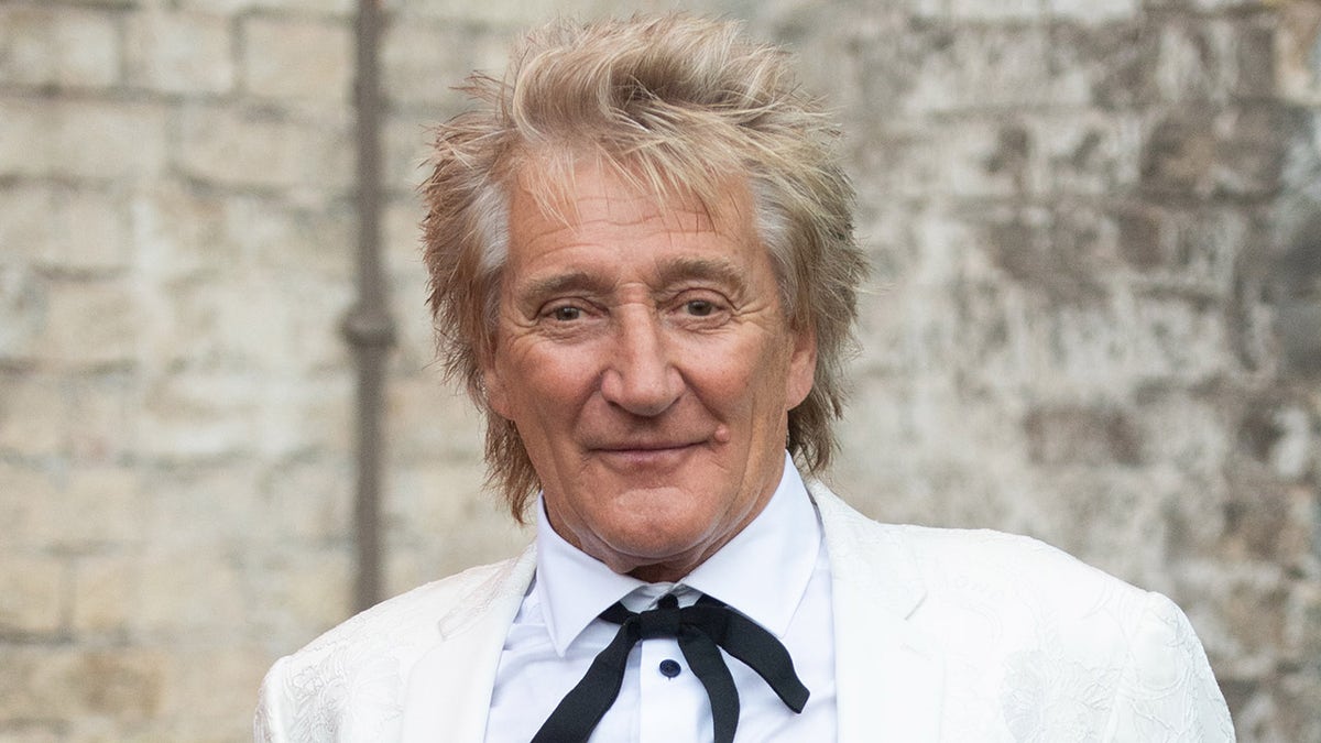 Rod Stewart sports a bolo tie with a white suit
