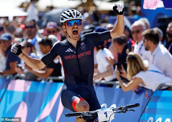 Paris 2024 Olympics - Mountain Bike - Men's Cross-country - Elancourt Hill, Elancourt, France - July 29, 2024. Thomas Pidcock of Britain celebrates after winning gold. REUTERS/Piroschka Van De Wouw