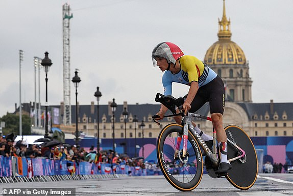 TOPSHOT - Belgium's Remco Evenepoel cycles by Invalides during the men's individual time trial at the Paris 2024 Olympic Games, July 27, 2024. (Photo by Emmanuel DUNAND / AFP via Getty Images)