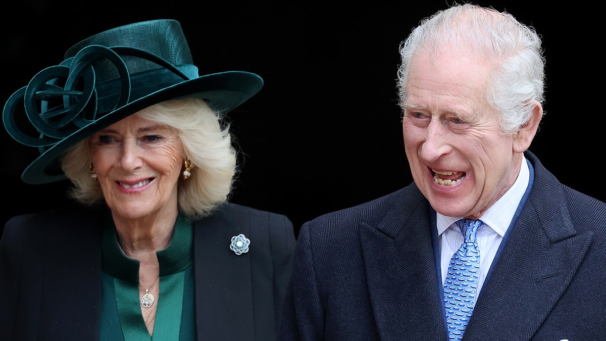 Queen Camilla smiles softly while walking alongside a cheerful King Charles.