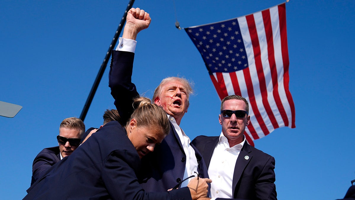 Donald Trump is surrounded by U.S. Secret Service agents at a campaign rally,