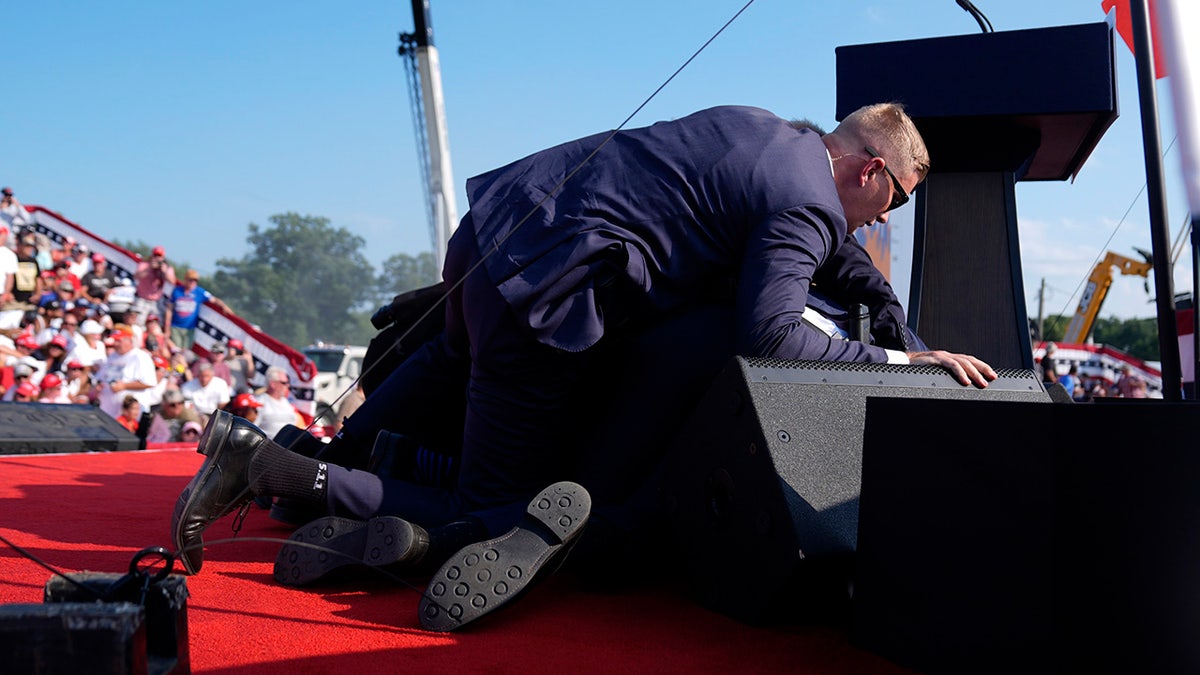 Former President Donald Trump surrounded by U.S. Secret Service agents during a campaign rally