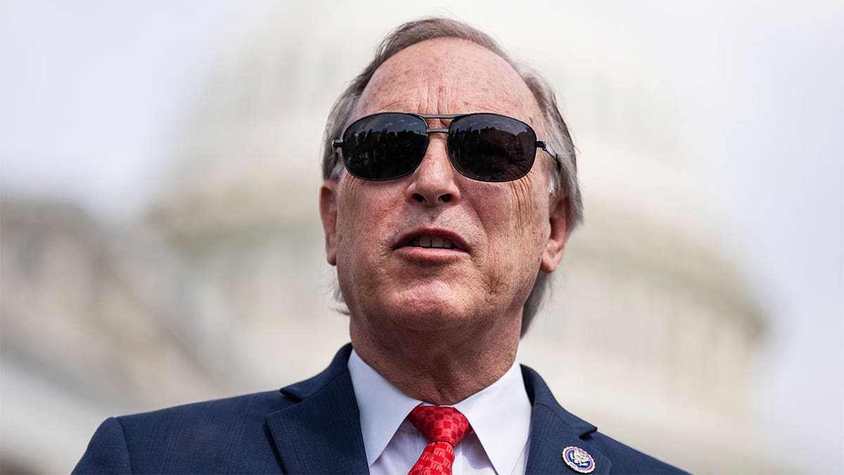 Rep. Andy Biggs with the U.S. Capitol in the background, wearing sunglasses