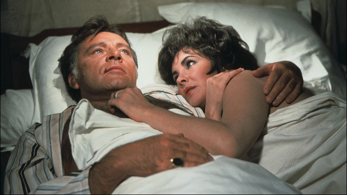 Elizabeth Taylor and Richard Burton in bed together.