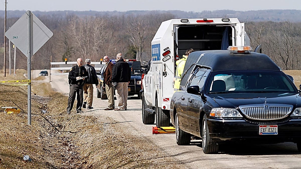 Police investigating a road where a victim's body was discovered.