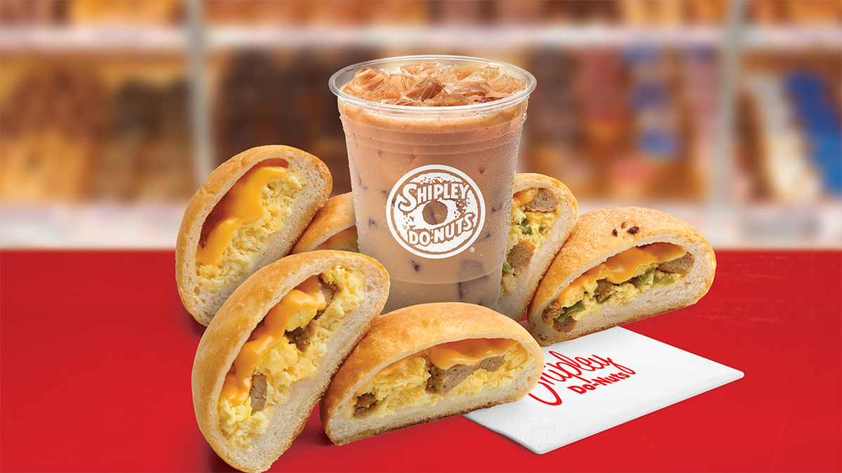 A group of kolaches placed around a Shipley Do-nuts cup.