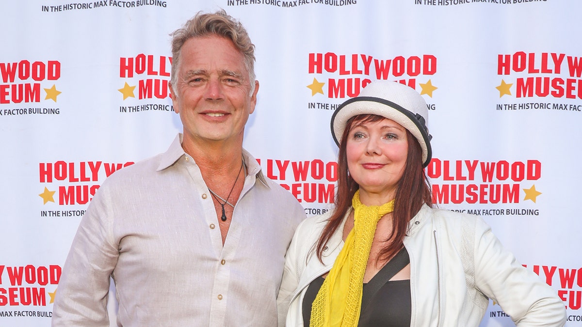 Actor John Schneider wearing a linen shirt with Dee Dee Sorvino by his side.